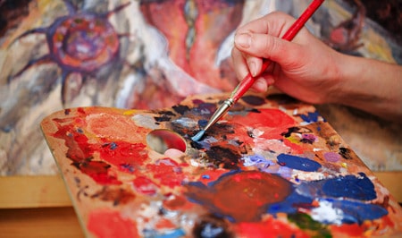 artist mixing oil paints on a palette