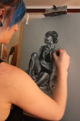 Young girl drawing with charcoal